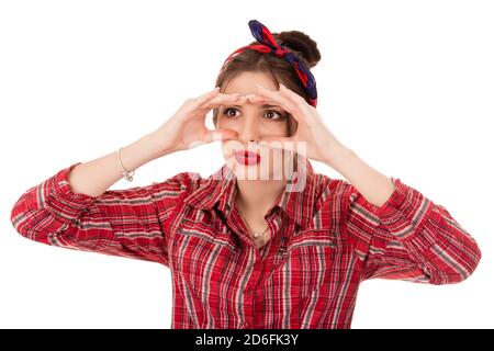 Peering Konzept. Closeup Portrait Junge ziemlich fassungslos neugierig Frau spähend Schauen durch die Finger wie Ferngläser auf der Suche nach etwas suchen t Stockfoto