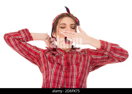 Portrait von müde Mädchen, das auf weißem Hintergrund gähnt. Closeup ausschnitt Porträt einer schönen Frau Mädchen tragen rot karierten geknöpfte Hemd Stockfoto