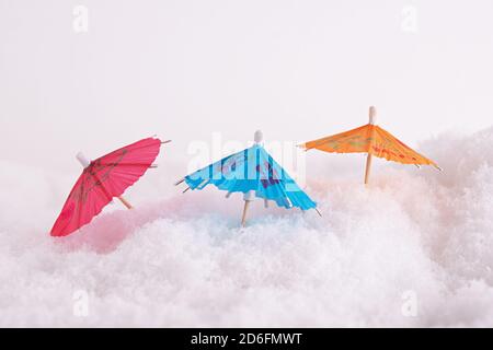 Nahaufnahme von bunten Papier-Cocktail-Schirmen im Schnee Stockfoto