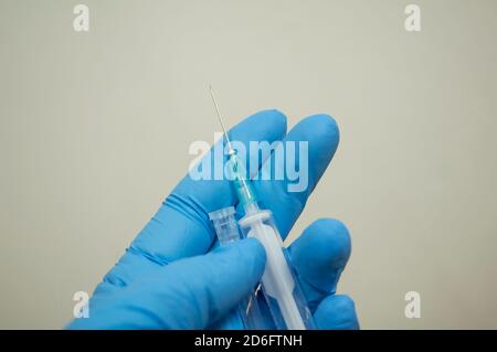 Eine Handschuhen hält eine leere Einwegspritze Stockfoto