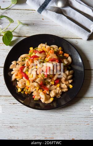 Vertikale Ansicht von oben gekochte Pasta auf einem schwarzen Teller Stockfoto