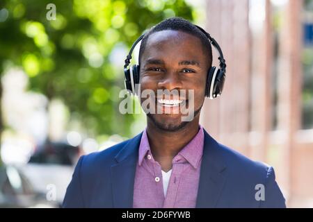 Afroamerikanischer Mann Hörmusik Auf Kabellosen Kopfhörern Draußen Stockfoto