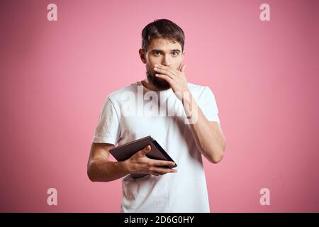 Mann wirbt eine Tablette auf einem rosa Hintergrund Codes Raum Beschnittene Ansicht der Emotionen weißes T-Shirt Modell neue Technologien Stockfoto