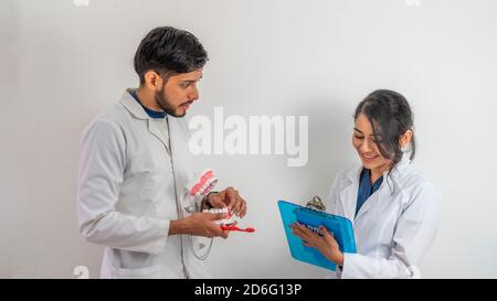 Junge hispanische Dentalhygieniker diskutieren ein Thema Stockfoto
