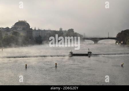 Nebliger Morgen in Prag, Tschechische Republik. Blick von der Karlsbrücke auf die Moldau und das Nationaltheater im Hintergrund. Stockfoto