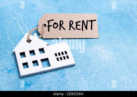 Haus zur Miete Label. Holzhaus Symbol mit Miete Tag auf blauem Hintergrund. Immobilien und Vermietung Wohnkonzept. Draufsicht Stockfoto