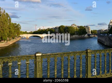 Blick auf den Sonnenuntergang von Pont d'Arcole mit grünem Geländer, Ile Saint-Louis, Place Louis-Aragon und Pont Louis-Philippe. Paris, Frankreich. Stockfoto