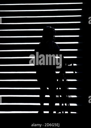 Schatten Silhouette einer Person schieben ein Fahrrad auf Außentreppe in der Nacht, hoher Kontrast schwarz und weiß Stockfoto