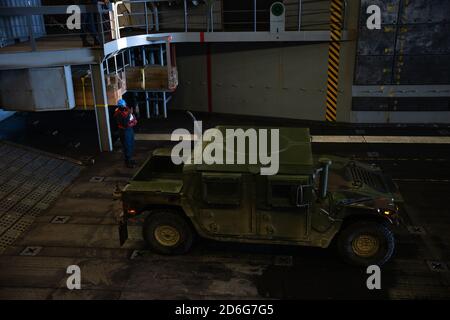 201010-M-JX780-1209 PAZIFISCHER OZEAN (OKT 10, 2020) ‒ EIN US-Seemann, der dem amphibischen Transportschiff USS Somerset (LPD 25) zugeordnet ist, leitet ein US-Marine Corps Humvee im Brunnendeck des Schiffes während des laufenden Betriebs. Die Makin Island Amphibious Ready Group und die 15. MEU führen derzeit Routineoperationen im östlichen Pazifik durch. (USA Marine Corps Foto von Lance CPL. Brendan Mullin) Stockfoto