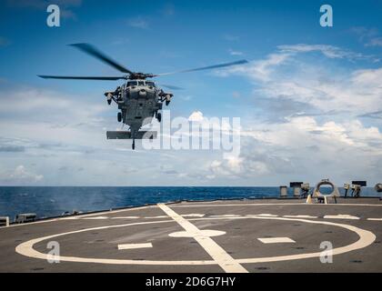 Ein MH-60S Sea Hawk Hubschrauber von der ‘Golden Falcons’ von Helicopter Sea Combat Squadron Twelve (HSC-12) bereitet sich auf das Flugdeck an Bord des Arleigh Burke-Klasse Geschoss USS John S. McCain (DDG 56) während des Flugbetriebs zu landen. McCain wird Destroyer Squadron Fifteen (DESRON 15) zugewiesen, der größten vorwärtseingesetzten DESRON der Marine und der wichtigsten Oberflächenkraft der US-Flotte der 7. Flotte. (USA Navy Foto von Mass Communication Specialist 2nd Class Markus Castaneda/veröffentlicht) Stockfoto