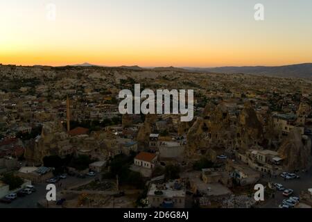 Abends Blick von oben auf die kleine Stadt Goreme. Sonnenuntergang in türkischem Kappadokien. Stockfoto