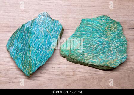 Zwei Stücke von schönen hellen semiprecious Mineral Amazonit liegen auf Eine hölzerne Oberfläche Stockfoto