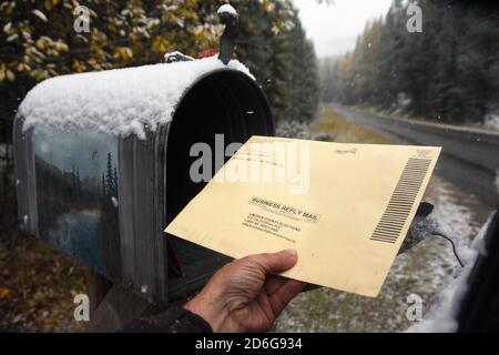Ein Bewohner im ländlichen Lincoln County Montana legt einen Wahlgang 2020 in seinem Briefkasten vor der Wahl am 3. November 2020. Stockfoto