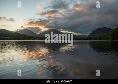 Atemberaubendes Landschaftsbild bei Sonnenaufgang mit Blick über Loweswater im See Bezirk in Richtung Low Fell und Grasmere mit bunten Himmel brechen Auf dem Berg Stockfoto