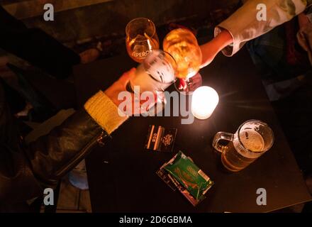 Berlin, Deutschland. Oktober 2020. Zwei Leute toasten vor einer Bar in Neukölln. Nirgendwo sonst in Deutschland ist die Zahl der Infektionen in letzter Zeit so stark gestiegen wie im Berliner Stadtteil Neukölln. Quelle: Christophe Gateau/dpa/Alamy Live News Stockfoto