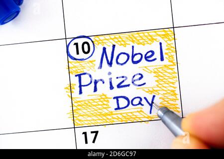 Frau Finger mit Stift Schreiben Erinnerung Nobelpreis-Tag im Kalender. Dezember 10. Stockfoto