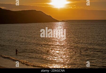 Langland Bay, Swansea, Großbritannien. Oktober 2020. Die Sonne geht heute Morgen in der Langland Bay nahe Swansea auf, während Schwimmer das Herbstwetter während des Lockdown optimal nutzen. Quelle: Phil Rees/Alamy Live News Stockfoto