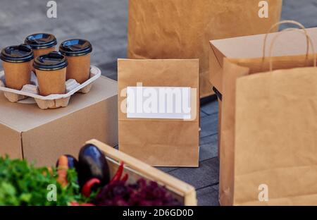 Papierpakete mit Kopierplatz, Lebensmittelgeschäft in Box und Kaffee. Konzept für die Lebensmittelzustellung Stockfoto