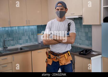 Junge kaukasische Werkstatt in Gesichtsmaske arbeiten mit Möbeln Stockfoto