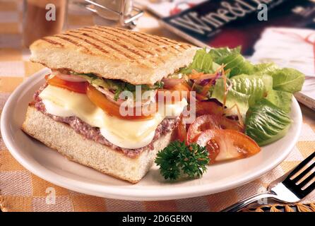 Sandwich mit Hackfleisch, Käse, Tomaten, Salat, geröstetem Brot und Salat Stockfoto