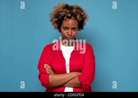 Wütend verärgerte afrikanische Frau, die die Arme gekreuzt hält und anstarrt Kamera mit skeptischem und misstrauischen Blick Stockfoto