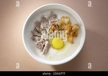 Congee oder Haferbrei mit Schweinefleisch, Krullern und Ei Stockfoto