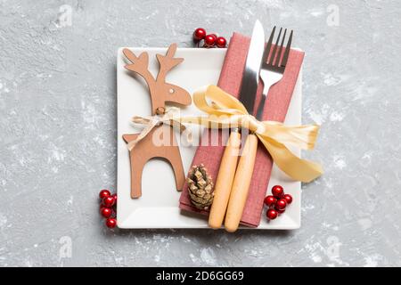 Ansicht von oben Urlaub Abendessen mit getrockneten Früchten und Zimt auf Zement Hintergrund eingerichtet. Satz von Platte, urensil und Neues Jahr Dekorationen. Weihnachten tim Stockfoto