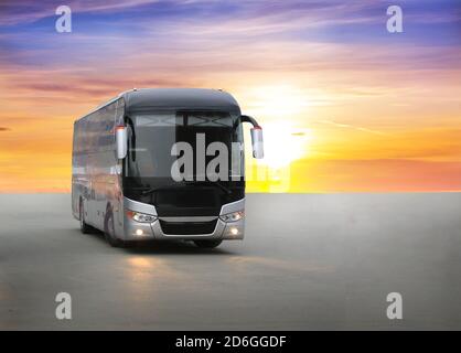 Moderne touristische Bus auf Asphalt am Abend auf den Sonnenuntergang Stockfoto