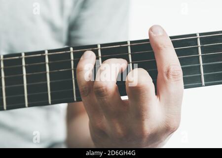 Gitarristen spielen einen großen Barre Akkord auf dem Griffbrett einer klassischen Gitarre. Stockfoto