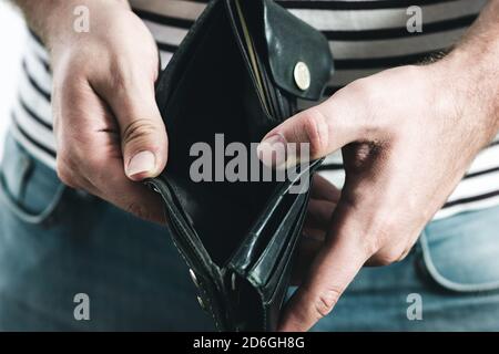 Hand des Mannes hält eine leere schwarze Brieftasche Stockfoto