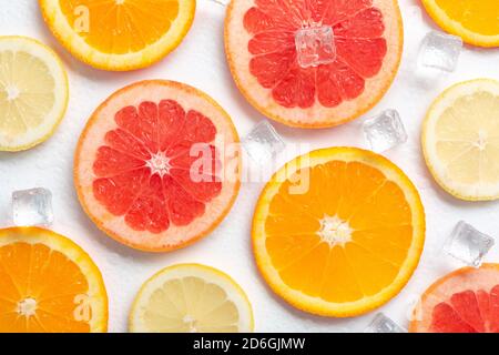 Scheiben Grapefruitorange und Zitrone mit Eis auf einem Weißer Hintergrund Stockfoto