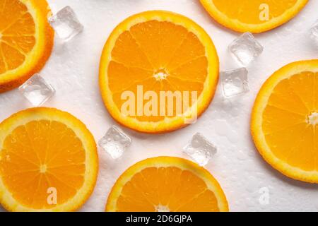 Orangenscheiben mit Eis auf weißem Hintergrund Stockfoto