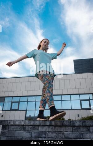 Blick von unten auf stilvolle Teenager in der Nähe Wolkenkratzer zu Fuß im Freien Stockfoto