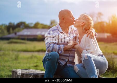 Glückliches Seniorenpaar Dating, Umarmung und küssen im Freien bei Sonnenuntergang Stockfoto