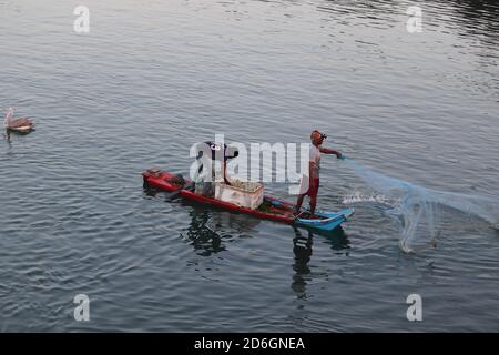 Chennai, Tamilnadu, Indien. Okt 18 , 2020.Fischer wirft Netze ins Wasser, um Fische vom Boot zu fangen Stockfoto