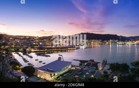 WELLINGTON, NEUSEELAND - 25. Feb 2020: Blick in die Dämmerung auf die Stadtgebäude und den Hafen von Wellington vom Mount Victoria aus. Wellington ist die Hauptstadt von Neuseeland. Stockfoto