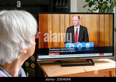 Professor Chris Whitty hält eine Pressekonferenz im Fernsehen über steigende Zahlen mit Covid 19, mit "Hände, Gesicht, Raum" Slogan. Stockfoto