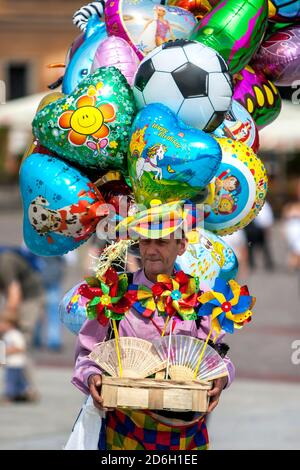 Ein Mann, der Luftballons und Wirbelstürme auf dem Schlossplatz in der Altstadt von Warschau in Polen verkauft. Stockfoto