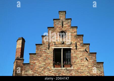 Das Detail der terrassierten Ziegelgiebel Wand des traditionellen historischen Hauses in Brügge in Belgien. Stockfoto