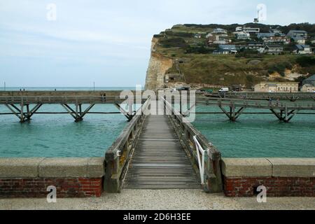 Die hölzernen Fußgängerbrücken über das Meerwasser führen zu den Leuchttürmen im Hafen der Stadt Fécamp in der Normandie in Frankreich. Stockfoto