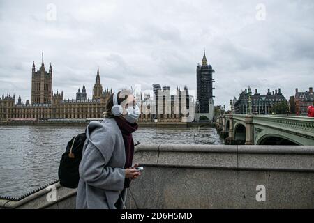 WESTMINSTER LONDON, GROSSBRITANNIEN 17. OKTOBER 2020. Ein Fußgänger, der vor dem Palce of Westminster und den Houses of Parliament läuft. London wurde nach einem rapiden Anstieg der Infektionen in vielen Londoner Stadtteilen unter (Medium Tier 2 Restriktionen) gestellt. Nach den neuen Richtlinien wird es Menschen aus verschiedenen Haushalten verboten, sich in Innenräumen zu treffen, und nur bis zu sechs Personen können sich im Freien treffen. Kredit: amer ghazzal/Alamy Live Nachrichten Stockfoto