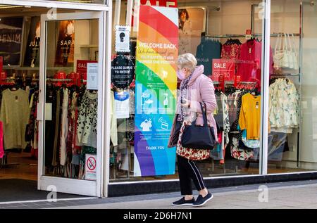 Dundee, Tayside, Schottland, Großbritannien. Oktober 2020. UK Wetter: Herbstsonne mit einer kühlen Brise durch Nordostschottland, Höchsttemperaturen 10 Grad Eine ältere Shopper, die am Bonmarche Bekleidungsgeschäft vorbeigeht und eine Gesichtsmask trägt und sich der Stay Safe-Bestimmungen im Stadtzentrum von Dundee während der Covid-19-Sperrbeschränkungen bewusst ist. Kredit: Dundee Photographics/Alamy Live Nachrichten Stockfoto