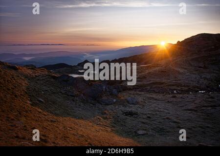 Landschaft von Rila und Pirin Bergen in Bulgarien bei Sonnenuntergang oder Sonnenaufgang. Schöne Aussicht während der letzten oder ersten Sonnenstrahlen. Stockfoto