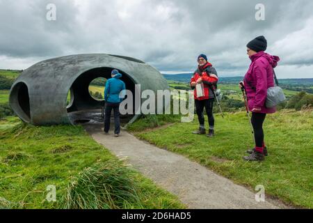 Drei Wanderer besuchen das Atom Panopticon: Eine Betonkuppel in atemberaubender Landschaft an einem regnerischen Sommertag während des Sturms Francis, Wycoller Stockfoto