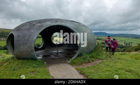 Drei Wanderer besuchen das Atom Panopticon: Eine Betonkuppel in atemberaubender Landschaft an einem regnerischen Sommertag während des Sturms Francis, Wycoller Stockfoto