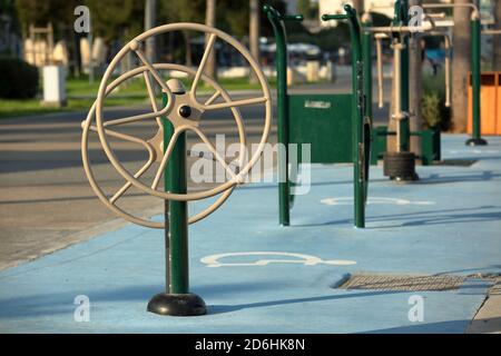 Outdoor-Fitnessraum mit speziellen Geräten für sportliche Aktivitäten, Rehabilitation für Menschen mit Behinderungen, im öffentlichen Park in Limassol, Zypern. Stockfoto