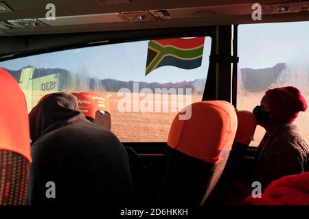 Passagiere, die während der Pandemie von Covid-19 in Südafrika in einem Bus (Reisebus) maskiert fahren. Stockfoto