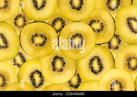 Fruchtiger Hintergrund aus vielen goldenen Kiwi-Scheiben Stockfoto