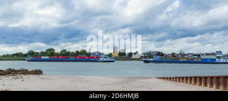 Tiel, Niederlande - 4. Oktober 2020: Skyline der Stadt Tiel mit Frachtschiffen über die Waal in Betuwe, Gelderland, Niederlande Stockfoto