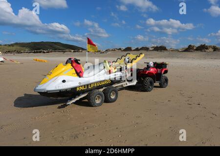 RNLI Life Guard Jet Ski am Sandstrand, Hayle, Cornwall, Großbritannien. 15/10/2020 RNLI Rettungsschwimmer. Schützen Gruppe von jungen Surfern Hayle Strand Stockfoto